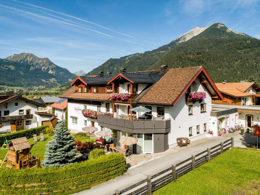 een groot wit huis met een berg op de achtergrond bij Appartementhotel Zugspitzhof in Ehrwald