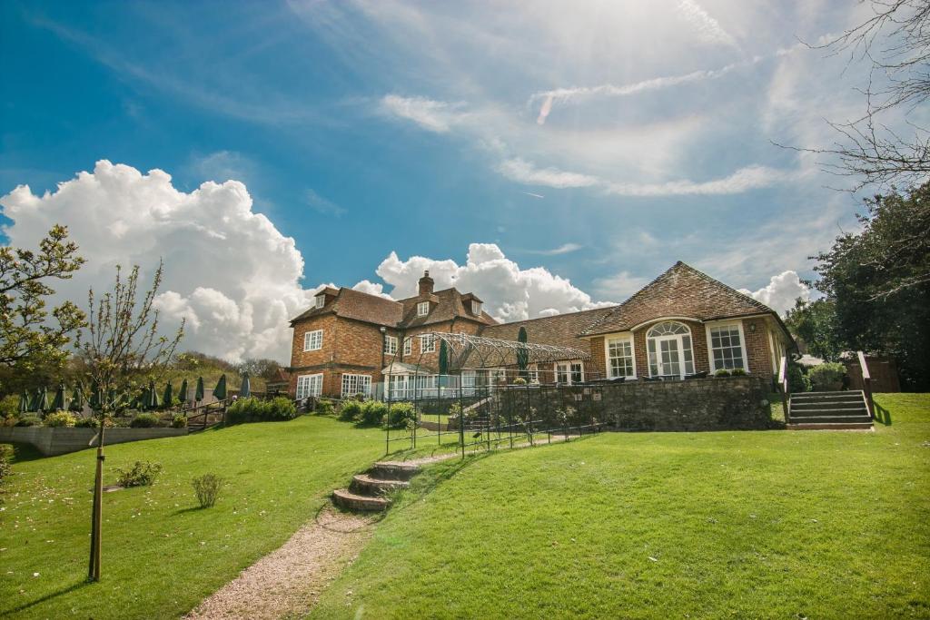 a large house with a grassy yard in front of it at Master Builder's House Hotel in Beaulieu