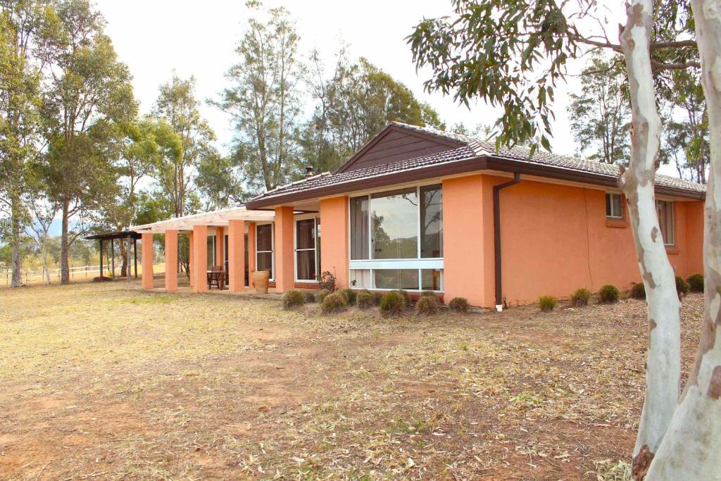 a small house with a large yard in front of it at Verona Vineyard Cottage in Pokolbin