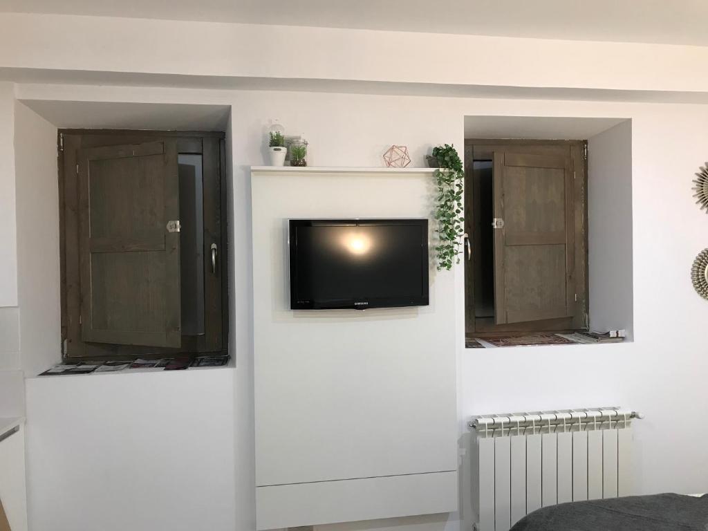 a living room with a tv on a wall at BELIA A.T. in Cáceres