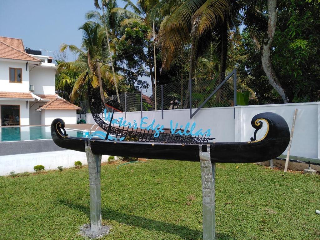 un banco en el césped junto a una piscina en Water's Edge Villas, en Alleppey