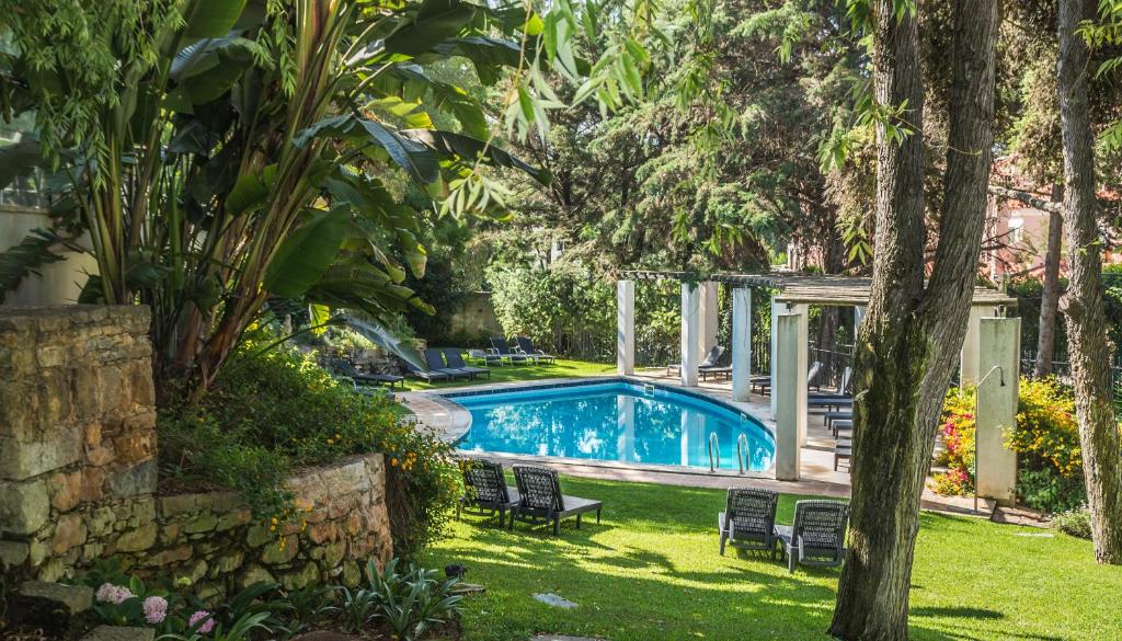 - une piscine dans une cour avec des chaises et des arbres dans l'établissement Casa Vela Boutique House, à Cascais