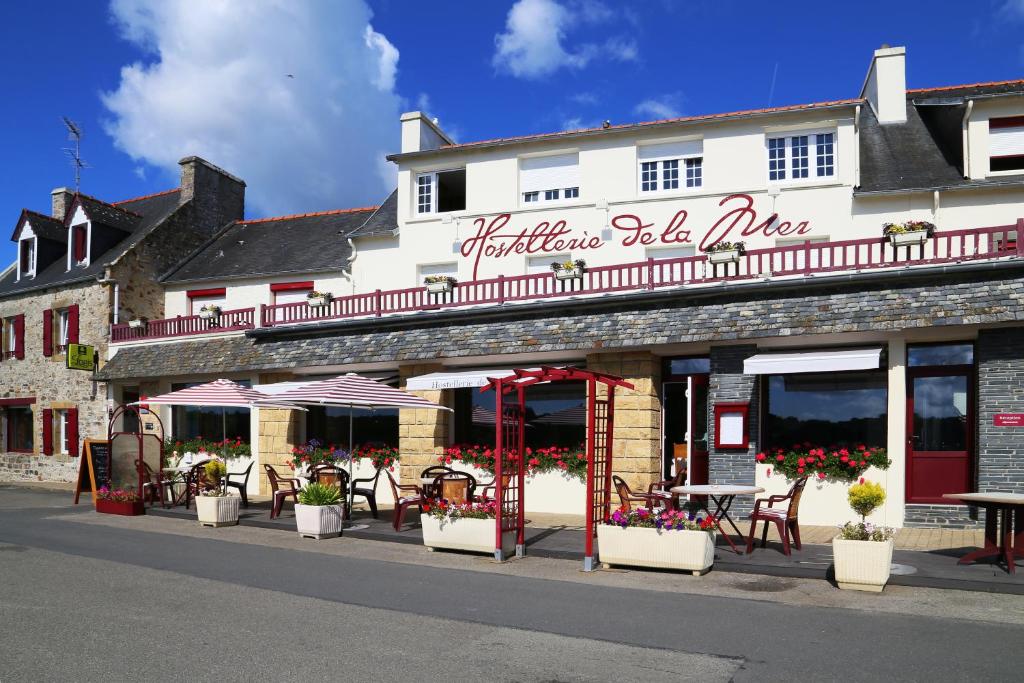 een gebouw met tafels en stoelen in een straat bij Hostellerie De La Mer in Crozon