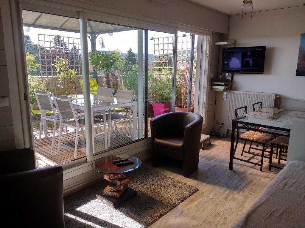 ein Wohnzimmer mit einem Balkon mit einem Tisch und Stühlen in der Unterkunft Datcha Bourguignonne Beaune in Beaune