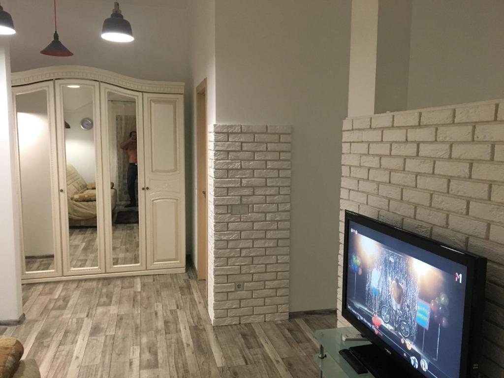 sala de estar con TV y pared de ladrillo en Comfort place in the city centre, en Ivano-Frankivsk