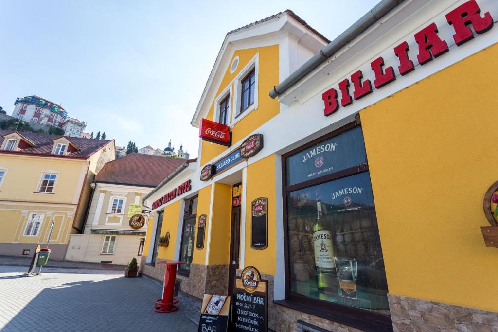 żółty budynek z znakiem na boku w obiekcie Country Saloon w mieście Vranov nad Dyjí