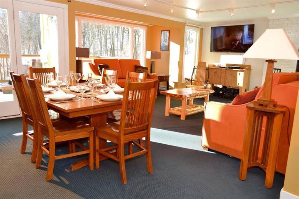 a dining room with a wooden table and chairs at Luxurious Trailside Village One Bedroom Condo #1 in Killington