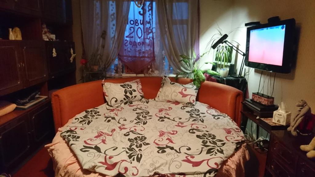 een slaapkamer met een bed met een deken erop bij Apartment on Raisy Okipnoi 5 in Kiev