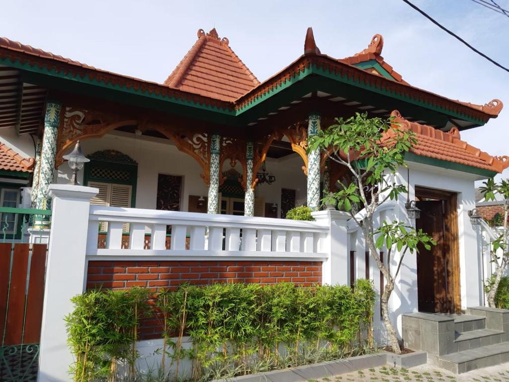 een huis met een wit hek ervoor bij Rumah Jawa Guest House (Syariah) in Yogyakarta