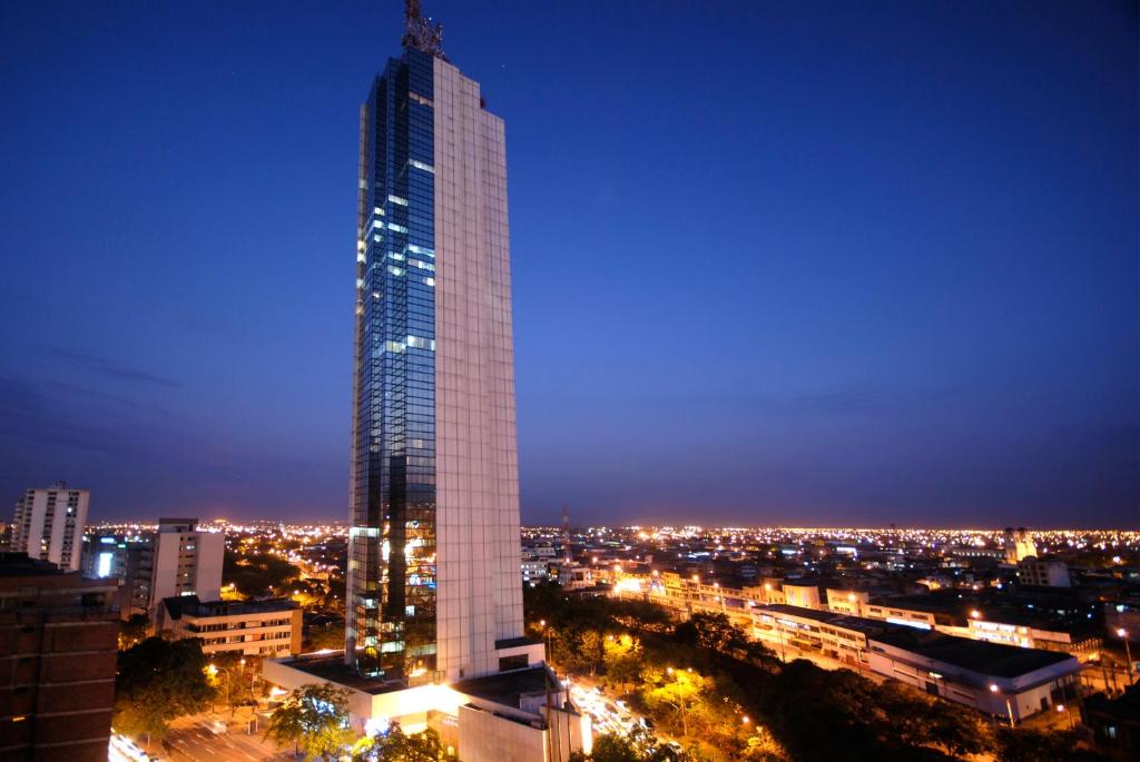 een hoge wolkenkrabber in een stad 's nachts bij Torre de Cali Plaza Hotel in Cali