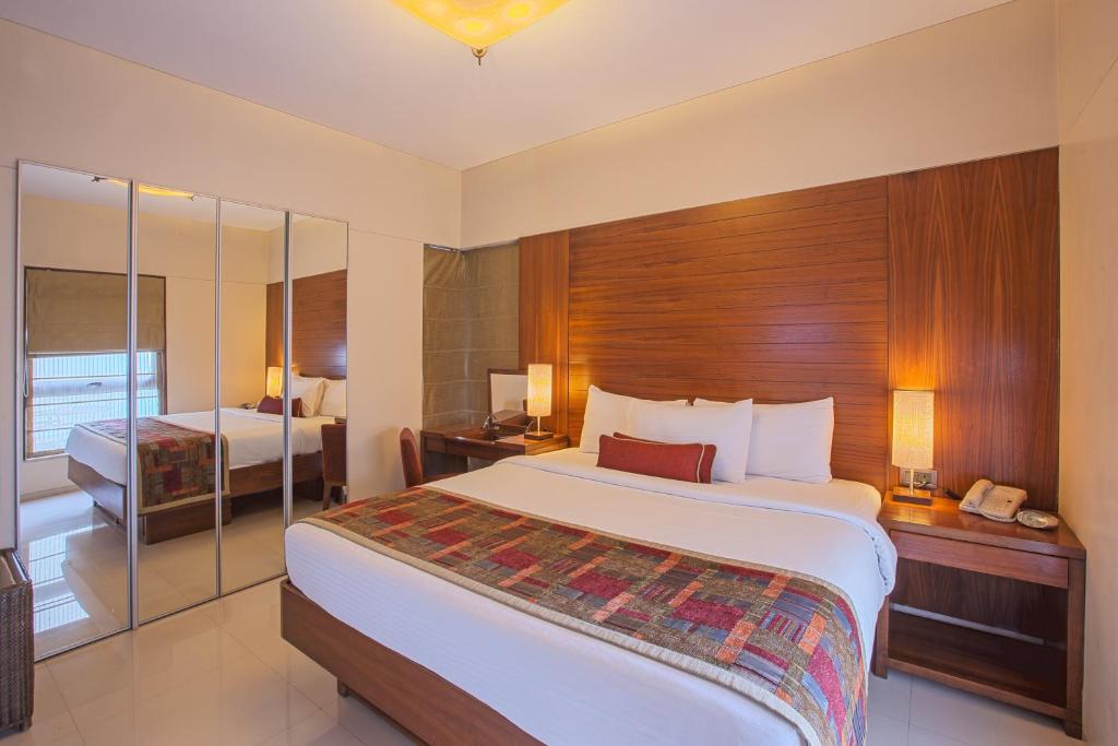 um quarto com uma cama grande num quarto de hotel em Oakwood Residence Naylor Road Pune em Pune