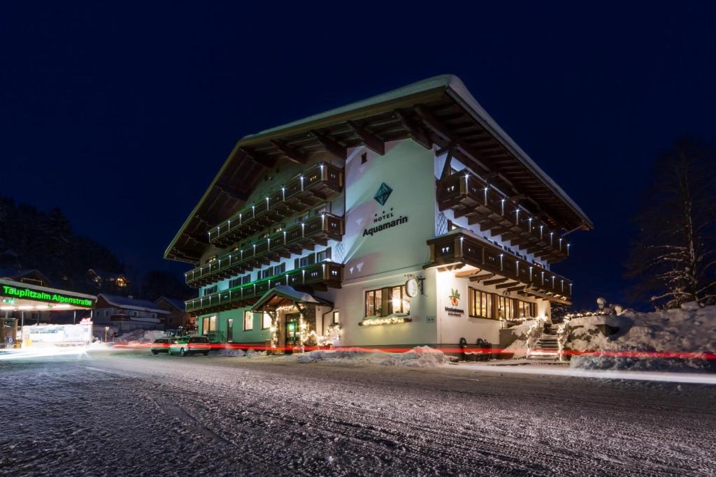 un gran edificio en una calle nevada por la noche en Hotel Aquamarin, en Bad Mitterndorf