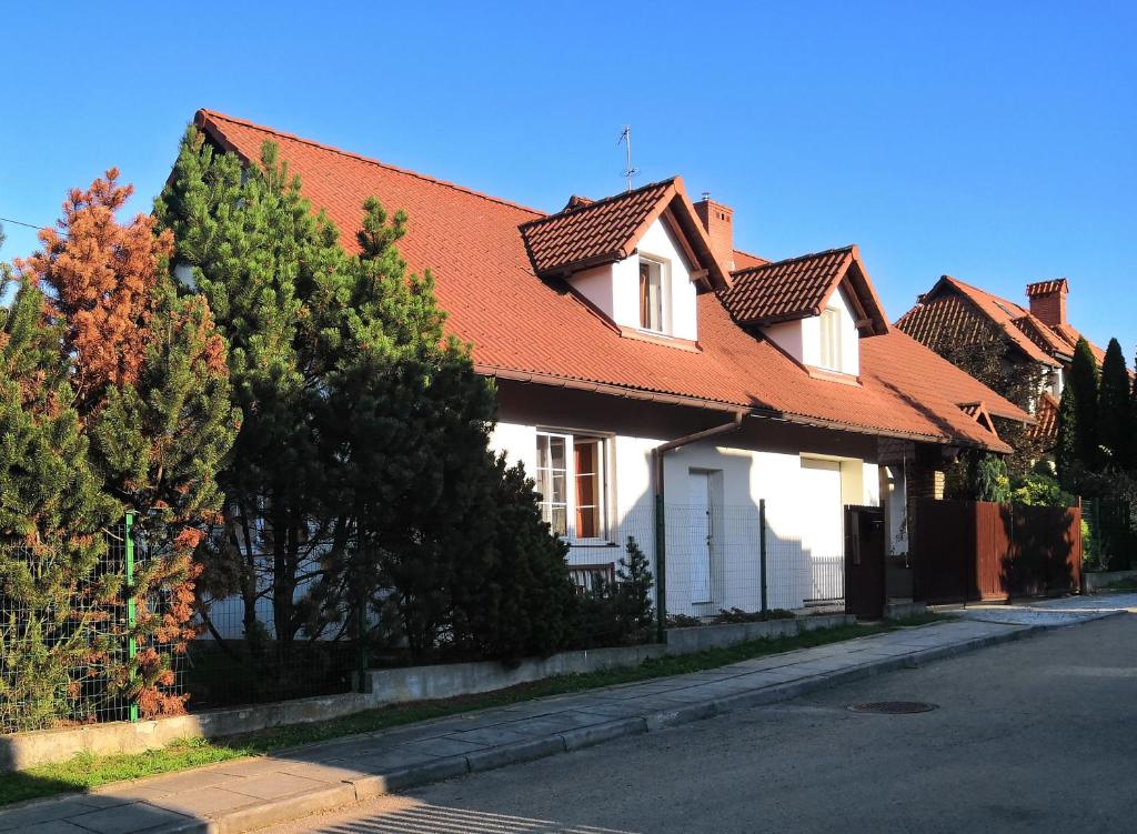 ein weißes Haus mit orangefarbenem Dach auf einer Straße in der Unterkunft Willa Elżbieta in Krakau