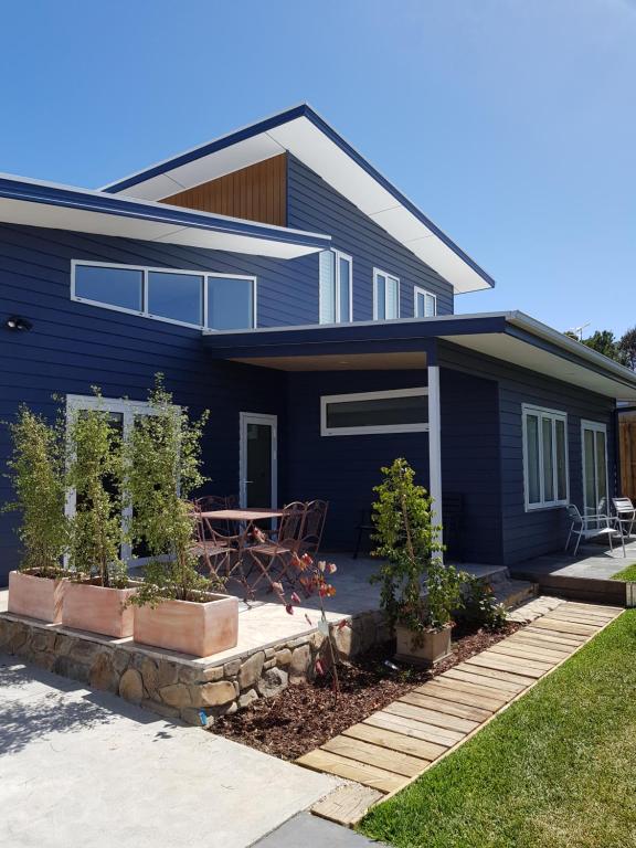 una casa azul con una mesa delante en Zeally Bay Stay Deep Ocean, en Torquay