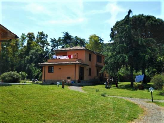 ein Haus mit einem Baum davor in der Unterkunft Podere 269 in Castiglione della Pescaia