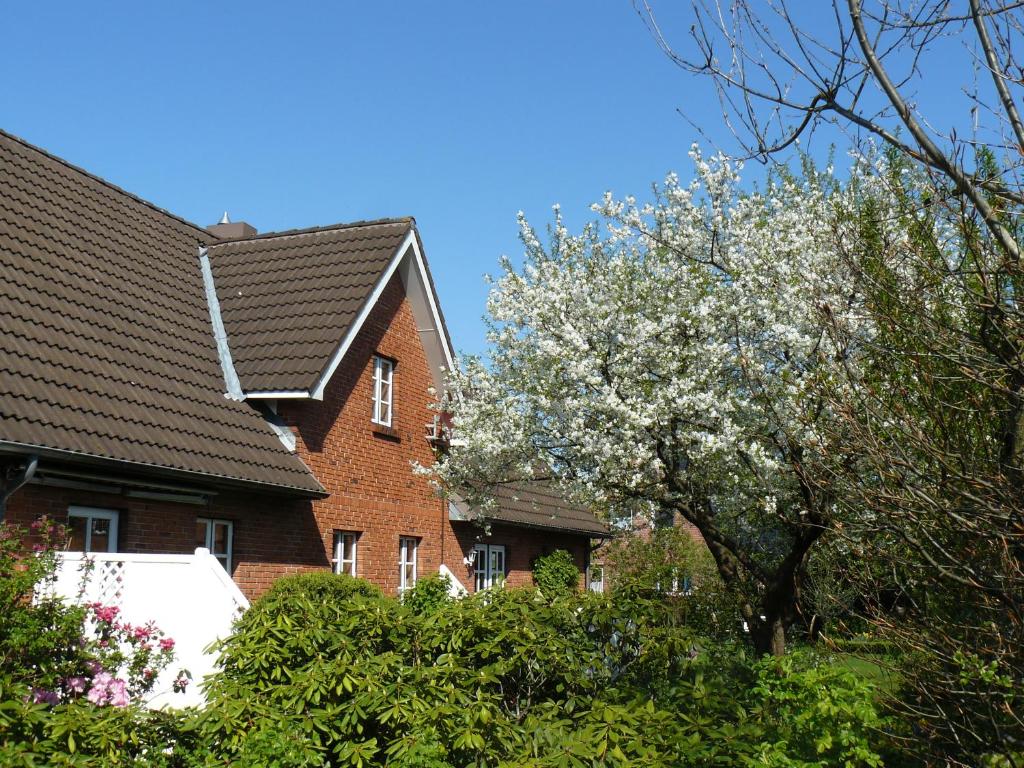 een bloeiende boom voor een stenen huis bij Ferienwohnung Seidler in Rendsburg