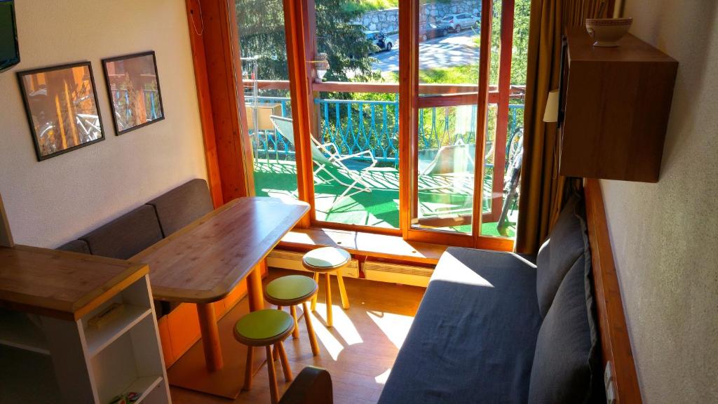 a living room with a table and a window at Duplex Le Vogel in Arc 1800