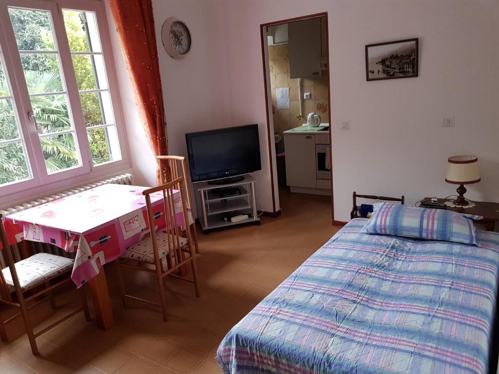 Habitación con cama, mesa y TV. en casa ubaldo, en Cannero Riviera