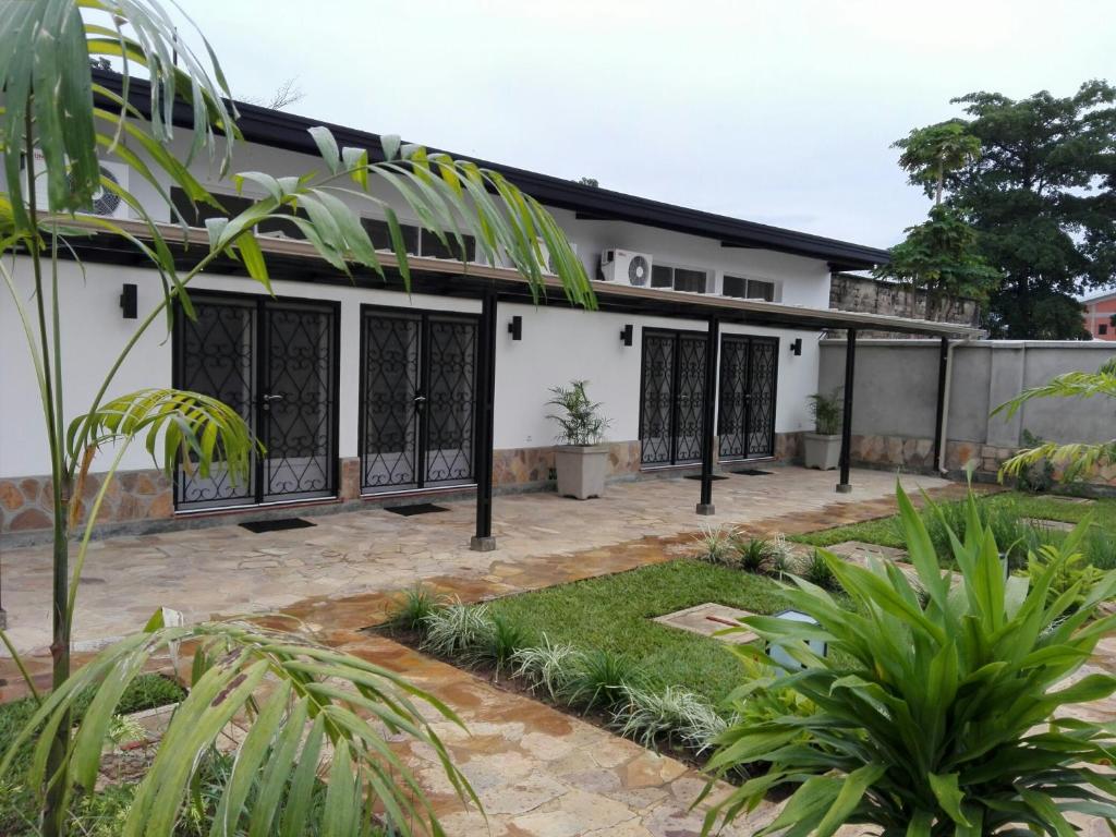 uma vista exterior de uma casa branca com portões pretos em Urban Lodge em Bujumbura