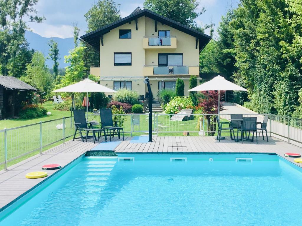 une maison avec une piscine en face d'une maison dans l'établissement Haus am Wald, à Faak am See