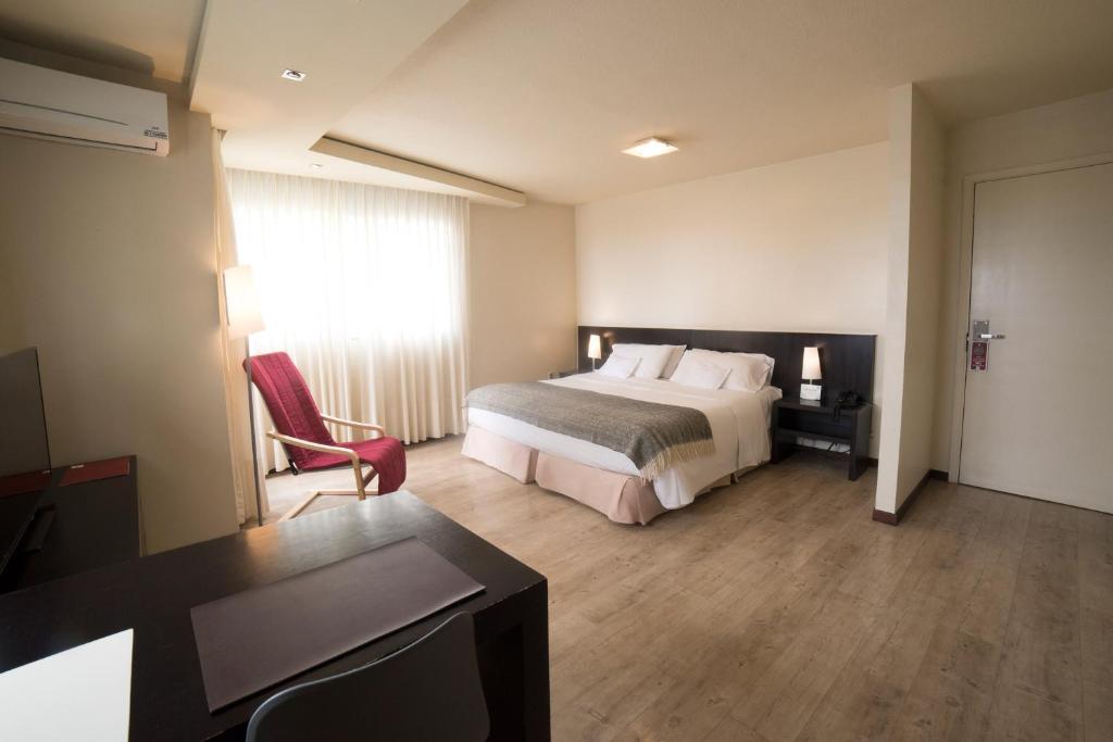 una camera d'albergo con letto e scrivania di 27 Suites Hotel a Montevideo