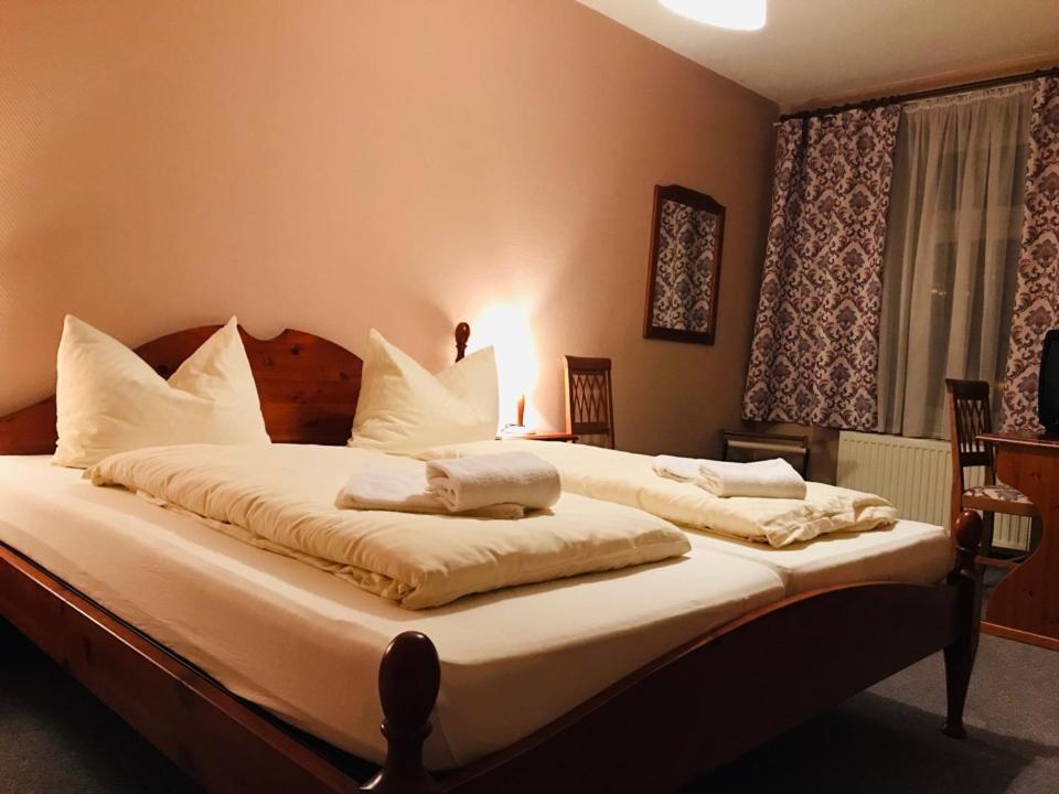 een slaapkamer met een groot bed met witte kussens bij Haus Schlematal Hotel und Restaurant in Bad Schlema