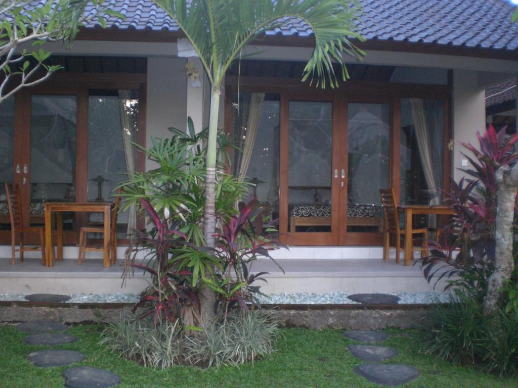 una casa con porche con sillas y plantas en Suka's House Bed & Breakfast, en Ubud