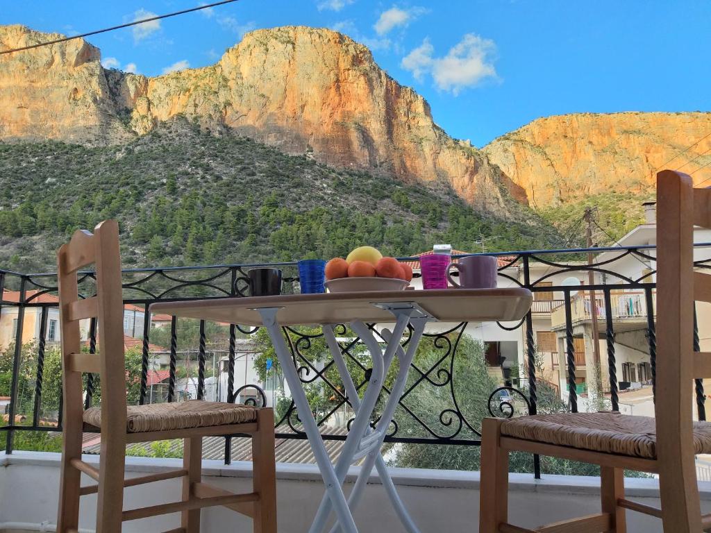 - une table avec des fruits sur le balcon avec une montagne dans l'établissement Delicatessen house, à Leonidio