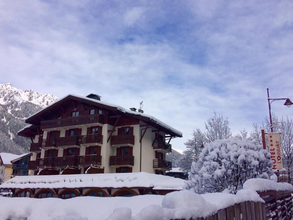 um edifício de apartamentos coberto de neve com um telhado coberto de neve em Oustalet em Chamonix-Mont-Blanc