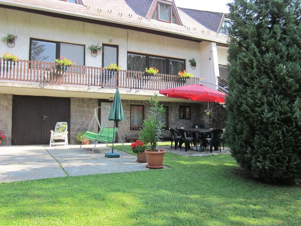 uma casa com um pátio com uma mesa e guarda-chuva em Tóth Vendégház em Parád