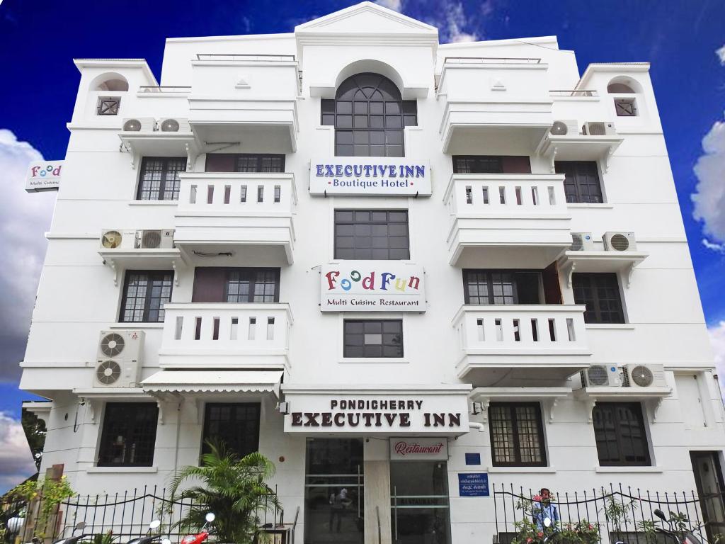 um edifício branco com um cartaz em Pondicherry Executive Inn em Pondicherry