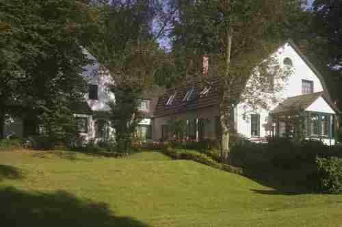 uma grande casa branca com um grande quintal em Hotel Buchenhof em Worpswede