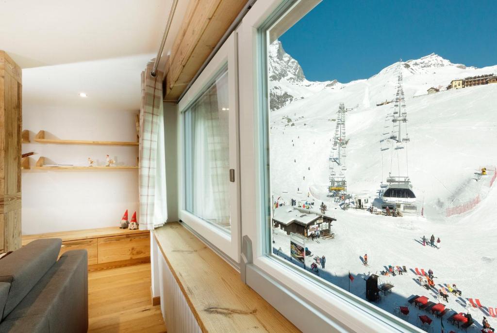 Cette chambre dispose d'une fenêtre offrant une vue sur la montagne. dans l'établissement HelloChalet - Maison Rêve Blanc - Ski to door with Matterhorn view, à Breuil-Cervinia