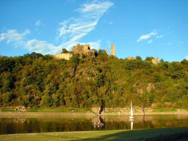 un castello in cima a una collina vicino a un lago di Pod hradem Cornštejn a Oslnovice