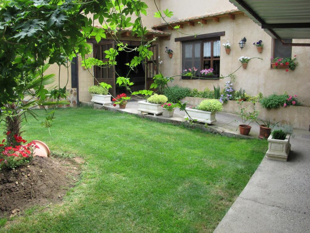 un cortile con piante in vaso e una casa di Albergue San Pelayo a Villarente