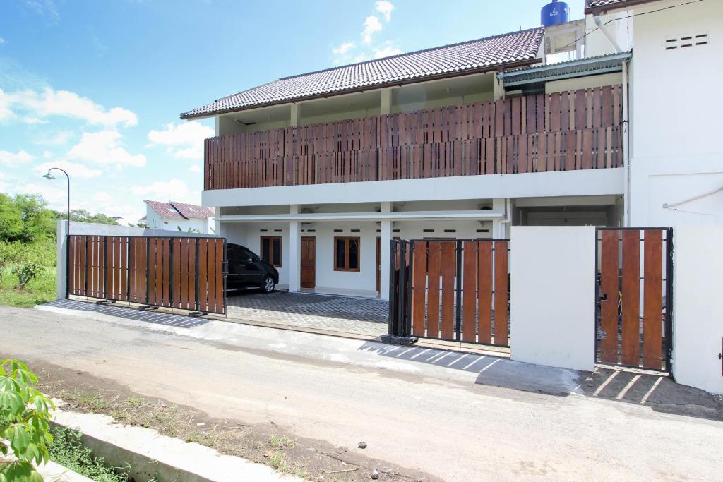 une maison avec des portes en bois et une voiture garée devant dans l'établissement Griya Izzara Guest House Syariah, à Sleman