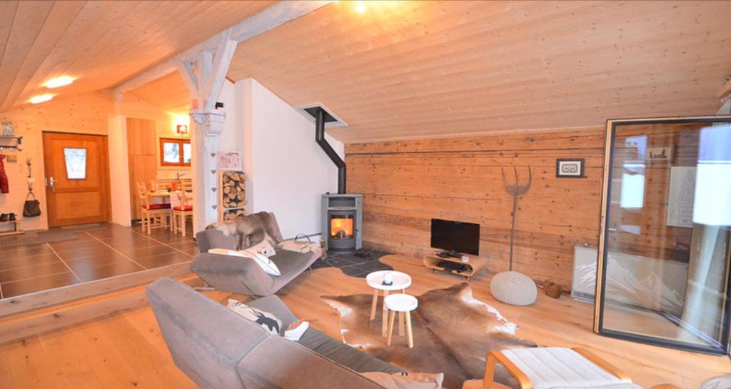 sala de estar con 2 sofás y chimenea en Chalet Rouge Coeur, en Fenalet Sur Bex