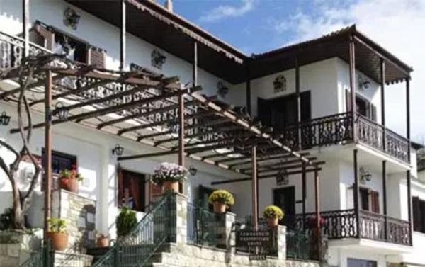 a large white building with balconies and plants on it at Pilioritiko Spiti in Makrinítsa