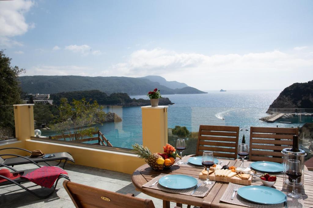 een tafel op een balkon met uitzicht op de oceaan bij Barbara's House in Paleokastritsa