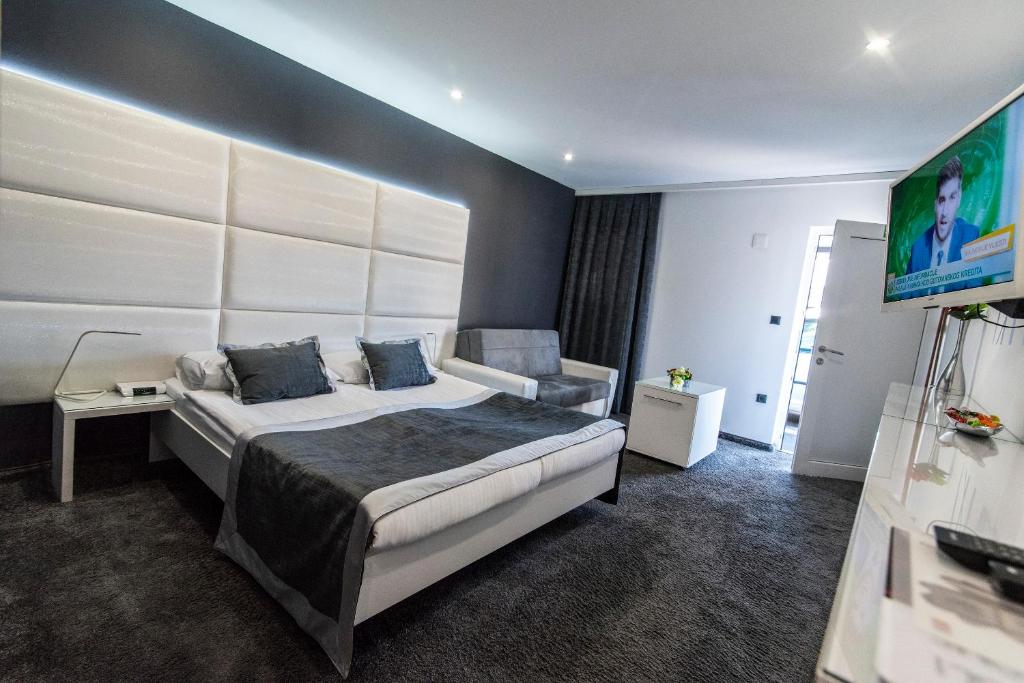 um quarto de hotel com uma cama e uma cadeira em Hotel Cool Zagreb Airport em Velika Gorica