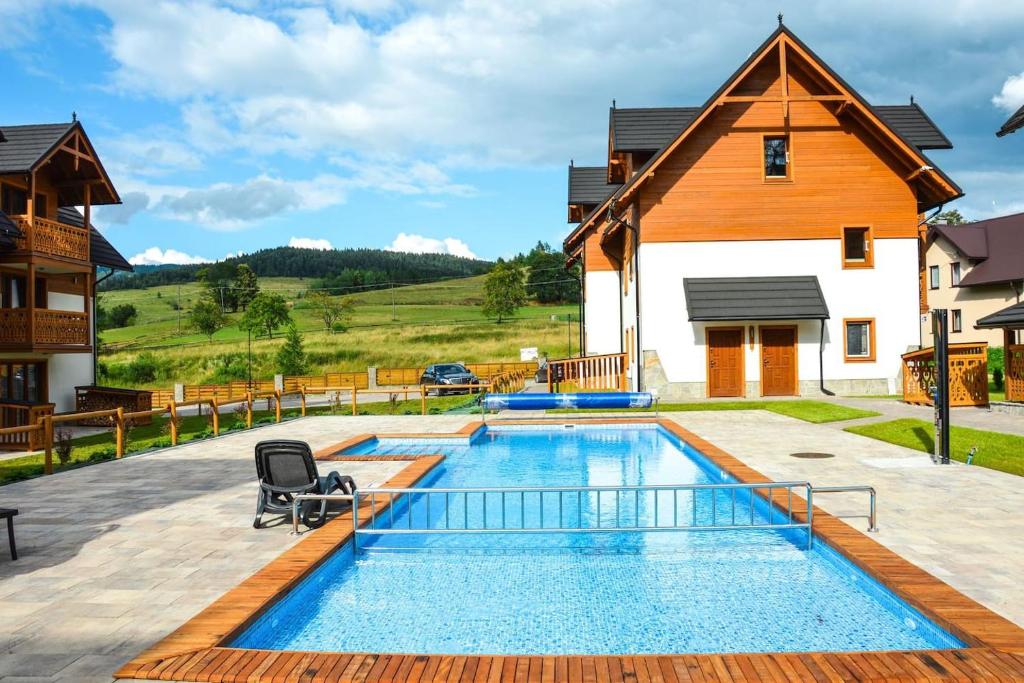 una piscina nel cortile di una casa con una casa di Przystań Góralska a Szczawnica