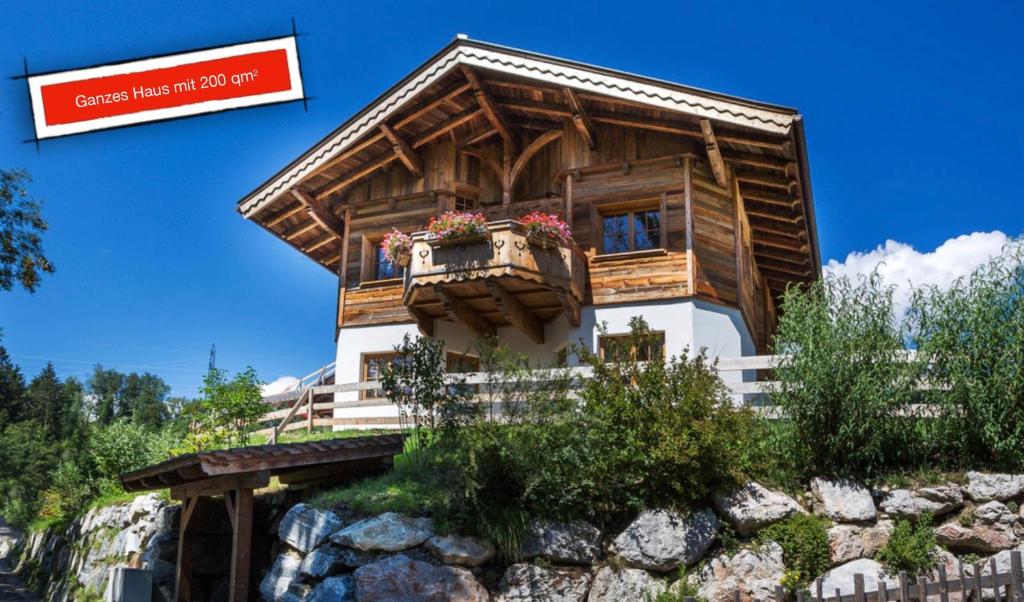 una casa in cima a una collina con un cartello di Family Retreat Maria Alm a Maria Alm am Steinernen Meer