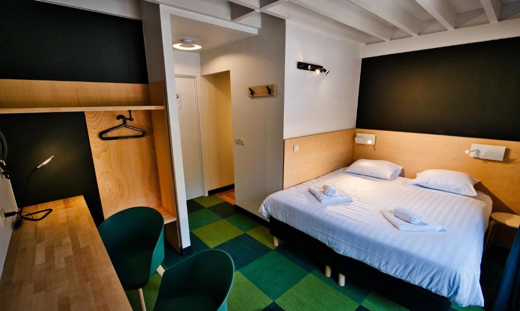 une chambre d'hôtel avec un lit et des chaises dans l'établissement Hotel Aquatel, à Dinant