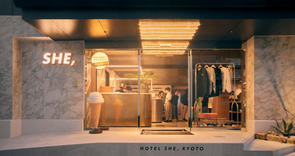 Hotel She, Kyoto في كيوتو: نافذة متجر مع امرأة في غرفة خلع الملابس