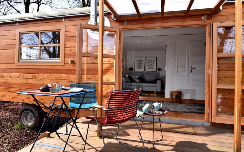 a tiny house with a table and chairs on a deck at Tiny House Dreischwesternherz in Trier