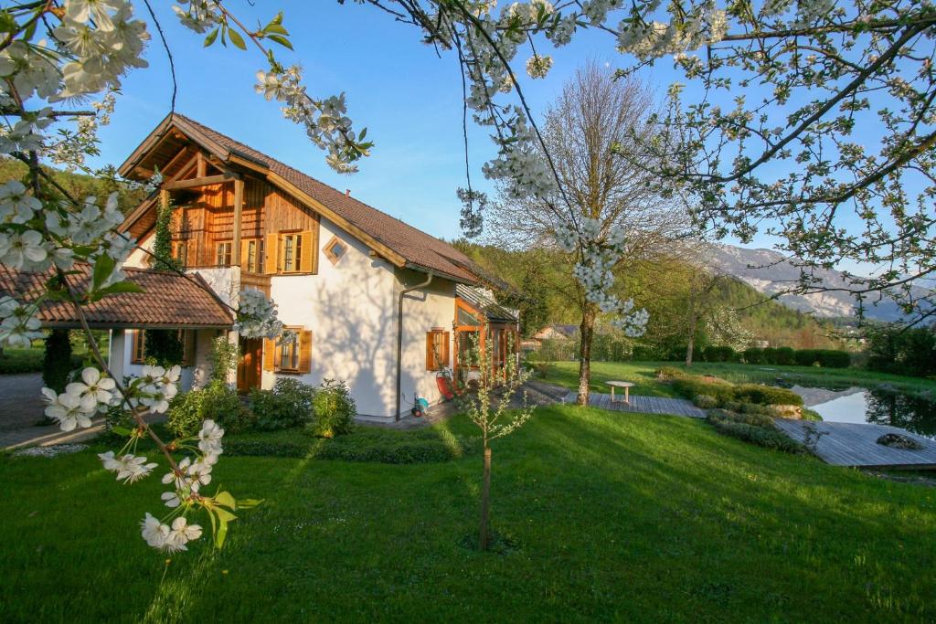 une maison avec une cour avec de l'herbe verte dans l'établissement Villa Anna Bad Goisern am Hallstättersee, à Bad Goisern