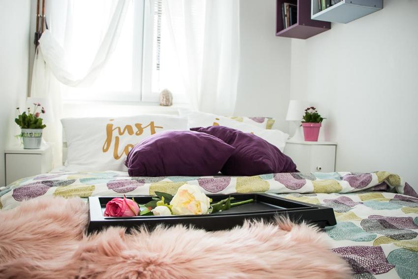 Una cama con una bandeja de flores. en Apartment Travel hub ***, en Varaždin