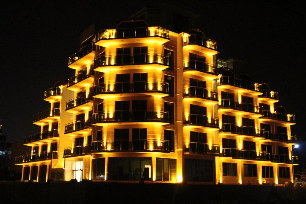 un condominio alto con le luci accese di notte di Legacy Hotel a Batumi