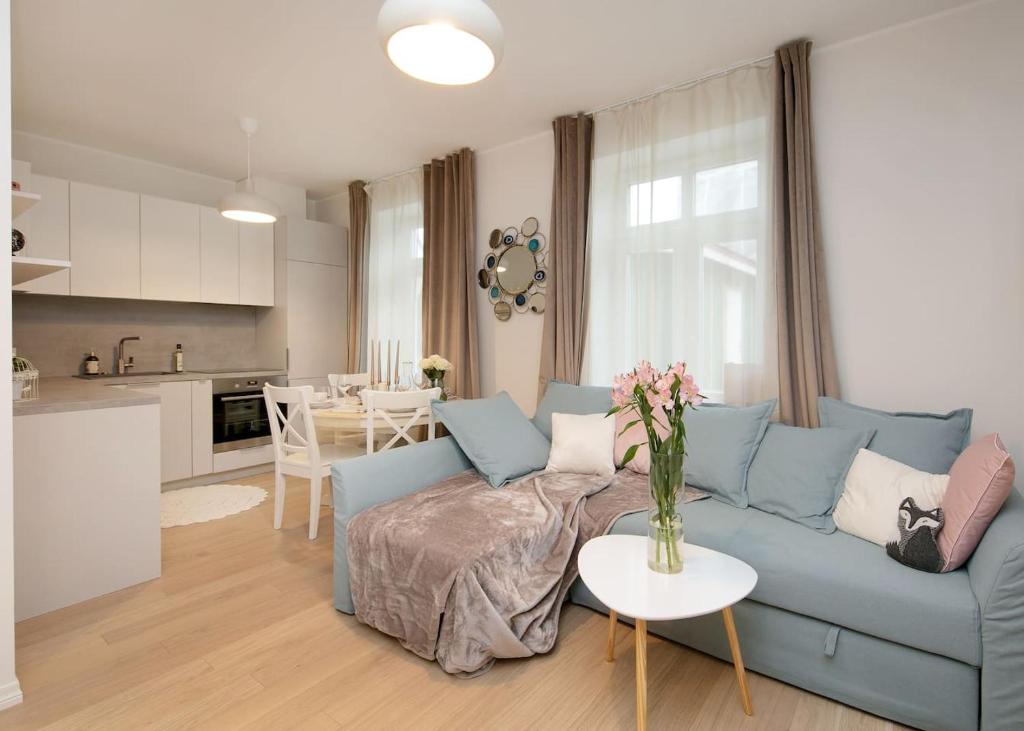 uma sala de estar com um sofá azul e uma mesa em Modern quiet 2 bedroom apartment near City center em Pärnu