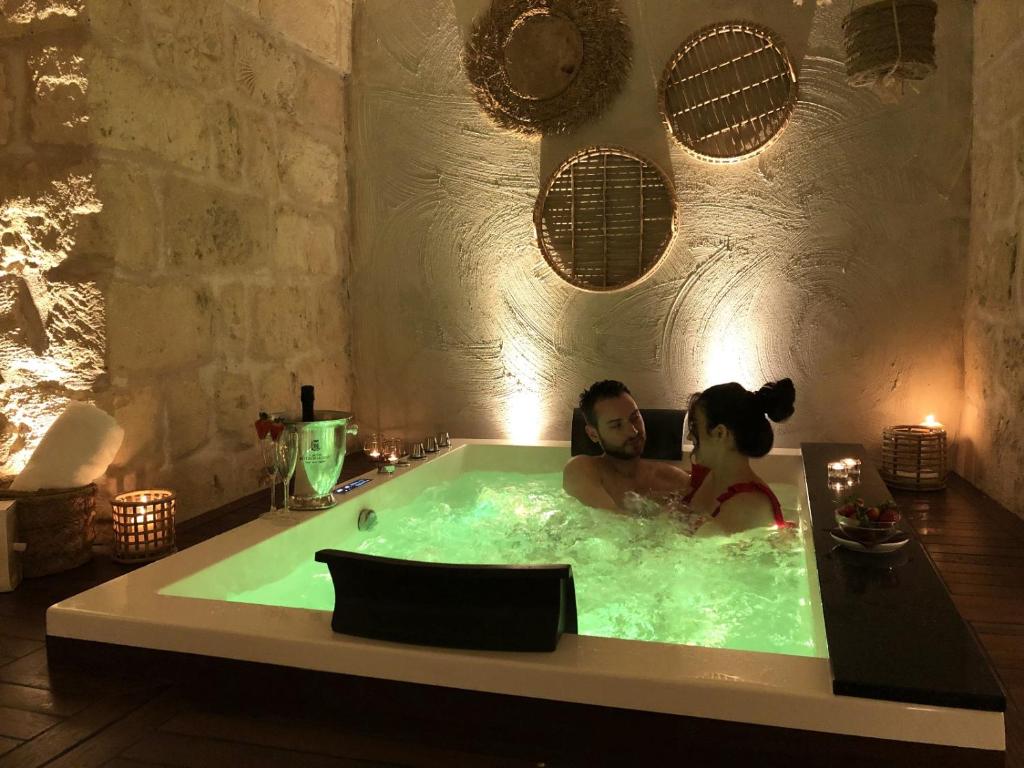 Ein Mann und eine Frau in einer Badewanne in der Unterkunft Le Fornaci Imperial Lodge & Spa in Gravina in Puglia